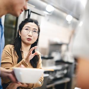 Wandi Wang talks to her class in a kitchen for a food lab.