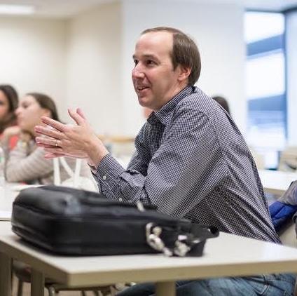 Jeff Helfin speaks sitting at a table