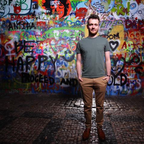 Ben Miller stands in front of graffiti wall