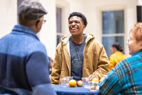 A students laughs standing with faculty and staff in Lehigh's global commons