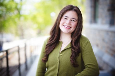 Rachel Gruber poses for a portrait outside wearing a green cardigan.
