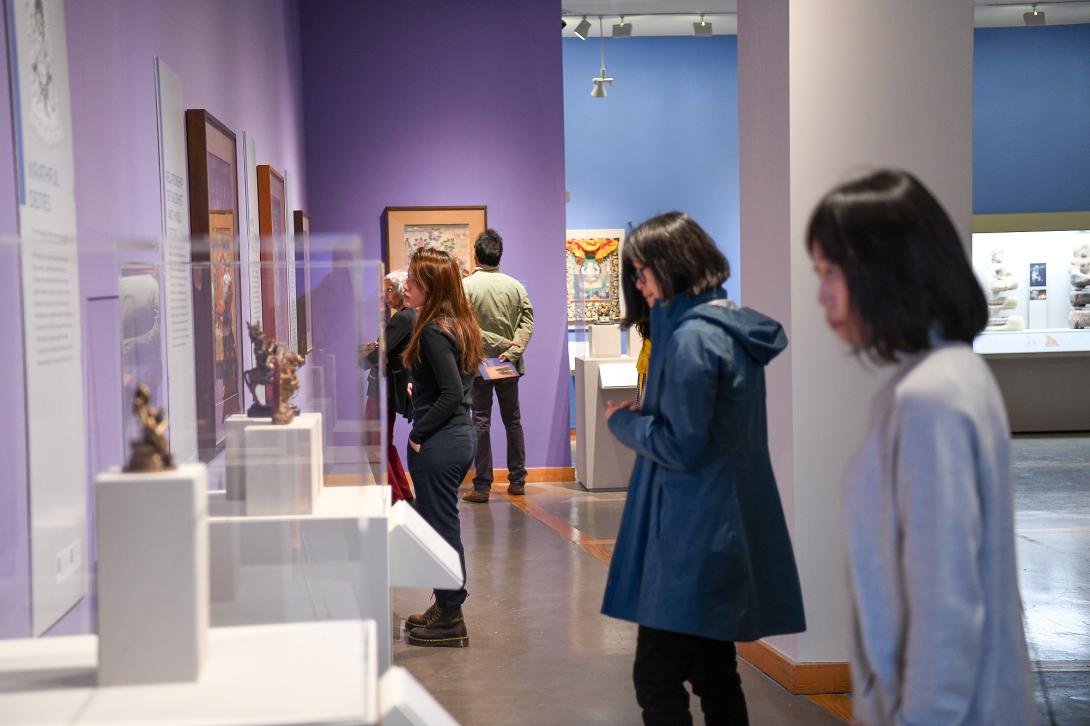 Students and faculty look at sculptures in a gallery