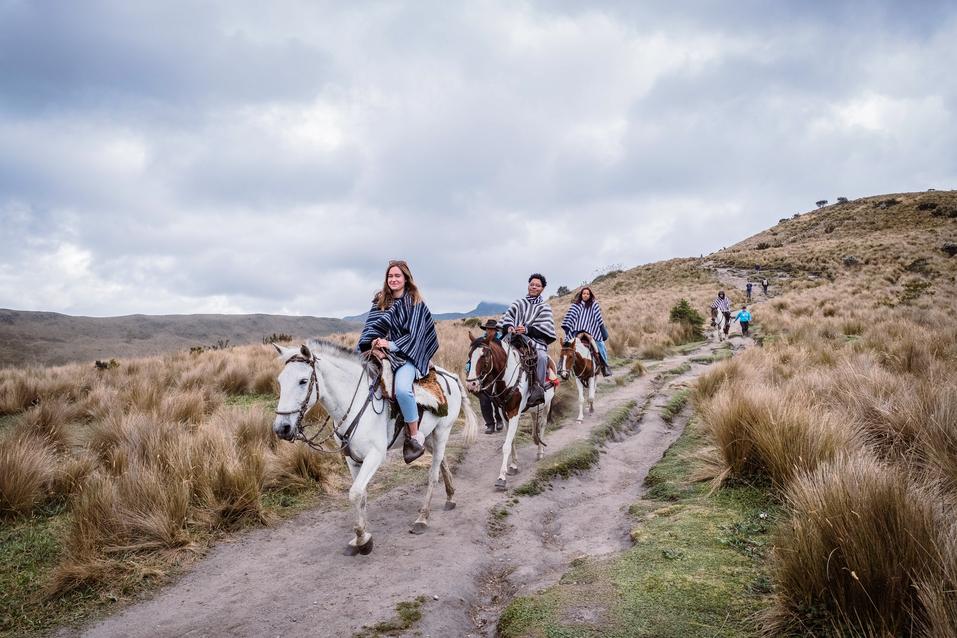 Students ride horses through a valley in Quito, Ecuador