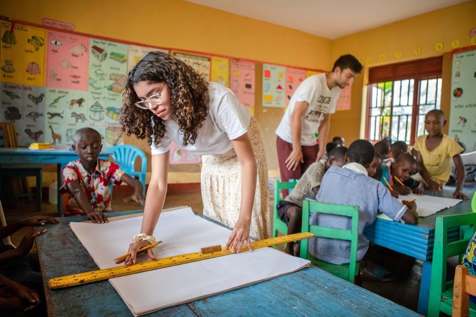 Genesis Genao prepares materials for an art project in a classroom in Uganda