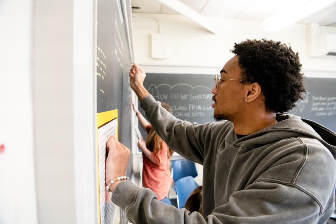 A student writes on a chalk board