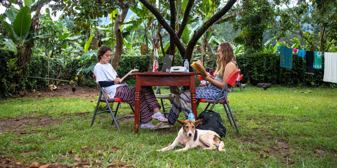 Quinnlyn Burger and Margaux Petruska sit at a table outside at the Zaale homestay.