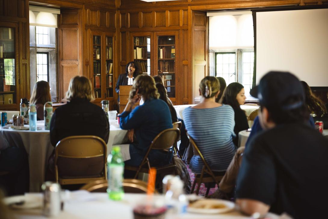 Stephanie Watts speaks at a podium in a library classroom.