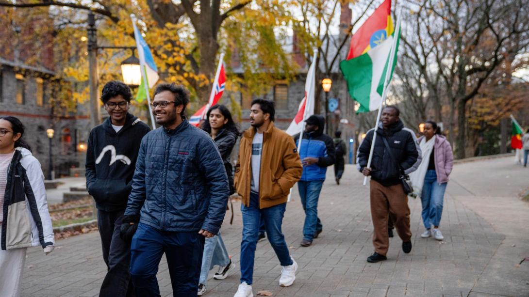 Lehigh students walk down the main street with flags from all around the world